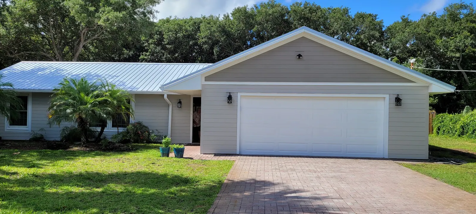 Single-storey house with a metal roof and a paver driveway